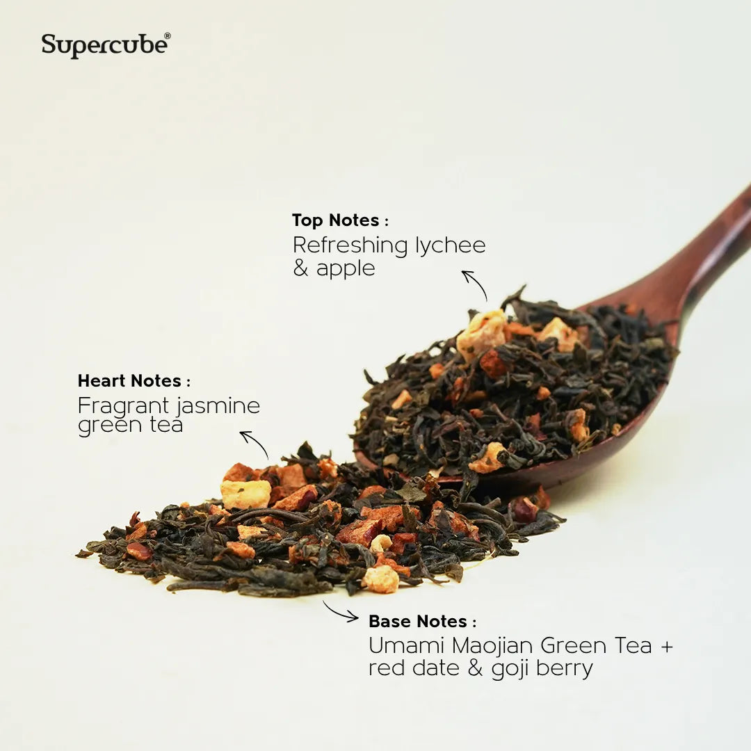 Supercube Jade Nectar Lychee Green Tea loose leaves on a wooden spoon showing lychee, jasmine and goji tasting notes