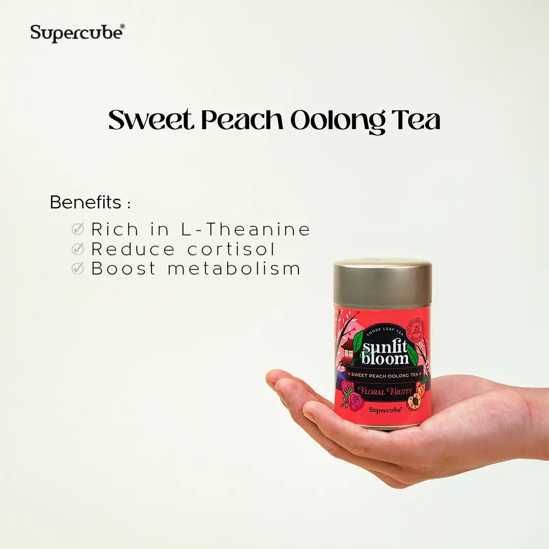 Hand holding Supercube Sweet Peach Oolong tin with benefits rich in L-theanine that support calm and metabolism