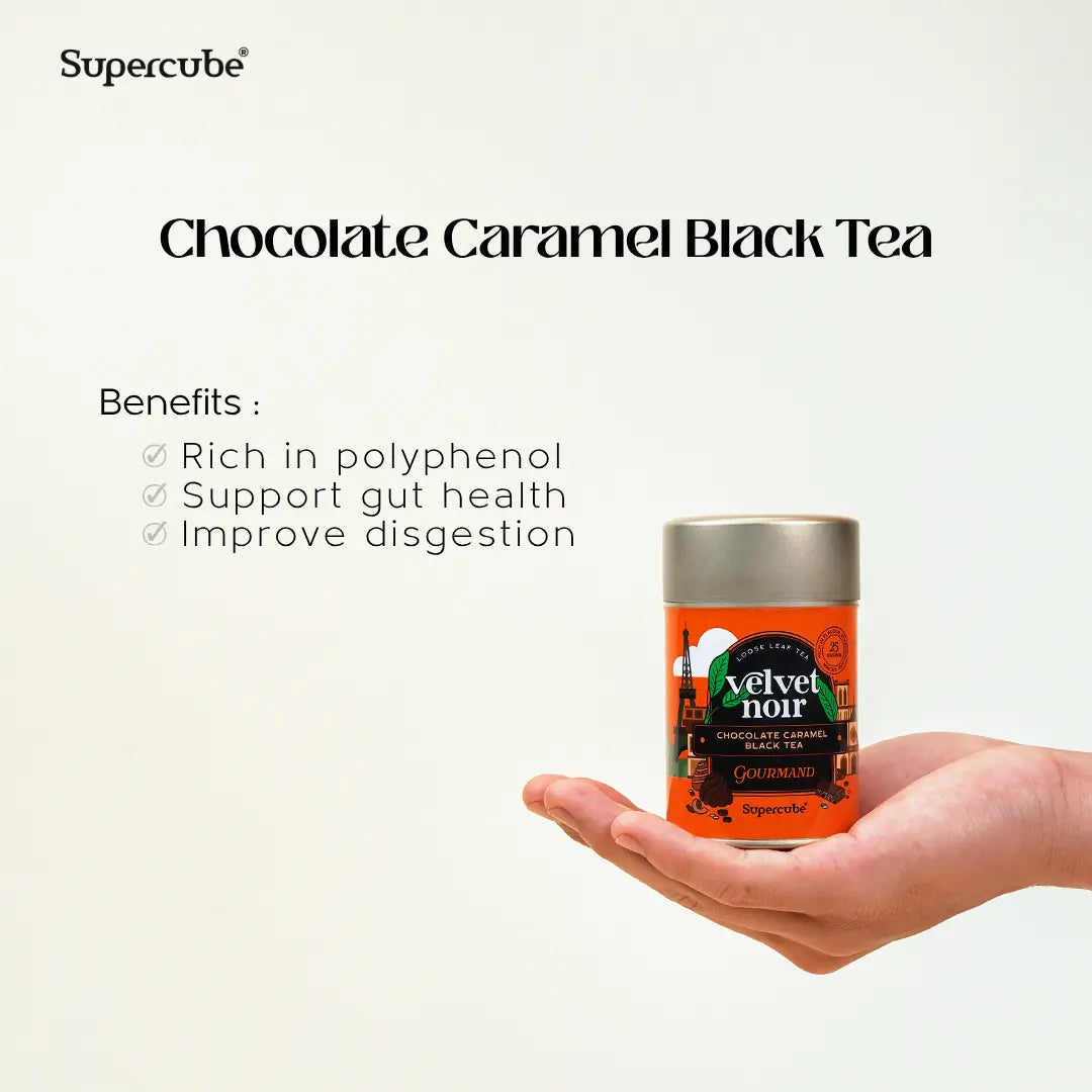 Hand holding Supercube Velvet Noir Chocolate Caramel Black Tea tin with benefits rich in polyphenols supporting gut and digestion